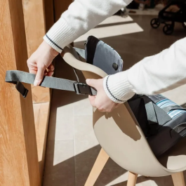 Nuby Siège réhausseur pour enfant avec harnais 3 points ajustable, à partir de 6 mois, design bleu à rayures, imperméable et portable en sac